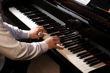 Man playing piano indoors, closeup. Talented musicianの写真素材