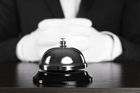 Butler at desk with service bell, closeup viewの写真素材