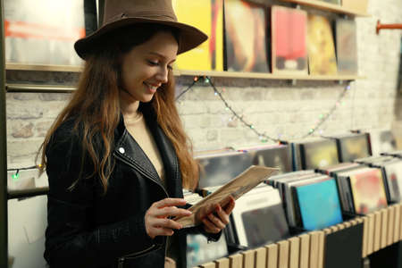 Young woman with vinyl record in storeの写真素材