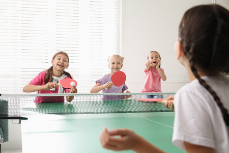 Cute happy children playing table tennis indoorsの写真素材