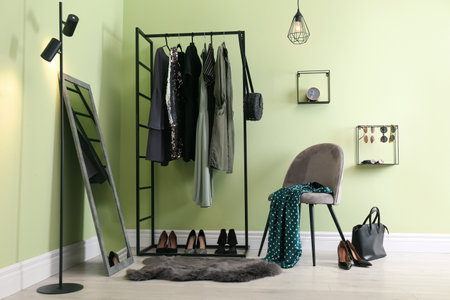 Modern dressing room interior with clothing rack, chair and mirrorの写真素材