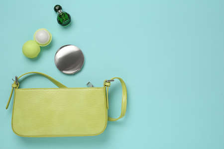 Flat lay composition with stylish baguette handbag on light blue background. Space for textの写真素材