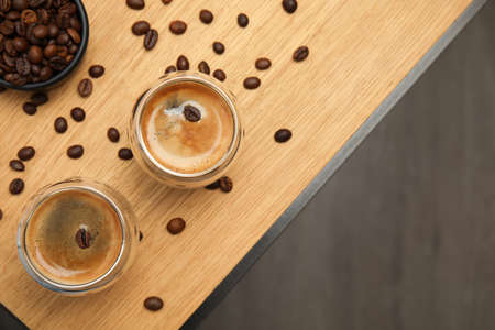 Tasty coffee and beans on wooden table, flat lay. Space for textの写真素材