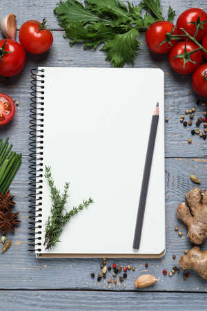 Open recipe book and fresh products on gray wooden table, flat lay. Space for textの写真素材