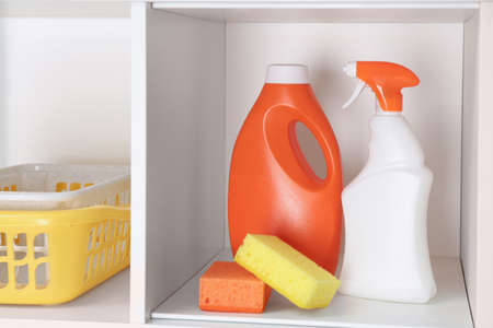 Bottles of detergents and sponges on shelvesの写真素材
