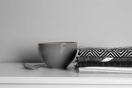 Kitchen towels and tableware on white countertop near wallの写真素材