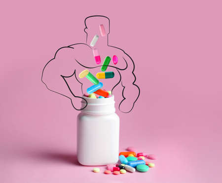 Doping concept. Plastic bottles with pills and silhouette of sportsman on pink backgroundの写真素材