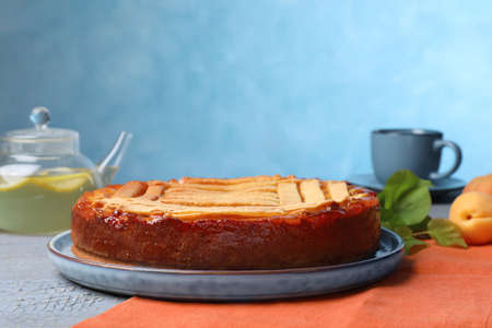 Tasty apricot pie on gray wooden table against light blue background, space for textの写真素材
