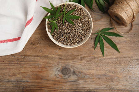Flat lay composition with hemp seeds on wooden table. Space for textの写真素材