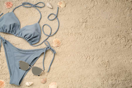 Flat lay composition with stylish bikini on sand. Space for textの写真素材