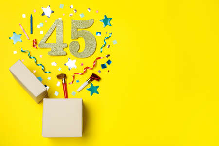 Flat lay composition with decor and numbers on yellow background, space for text. 45th birthday partyの写真素材