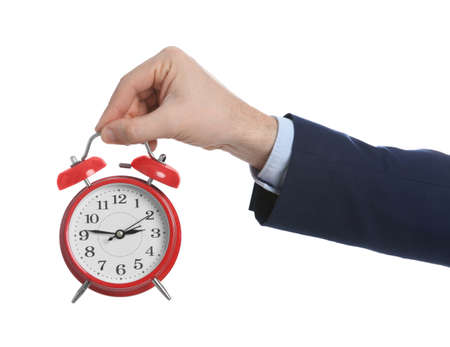 Businessman holding alarm clock on white background, closeup. Time managementの写真素材