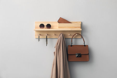 Wooden hanger for keys with different stuff on light gray wallの写真素材