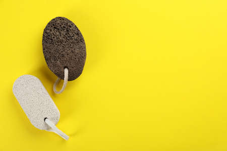 Pumice stones on yellow background, flat lay. Space for textの写真素材