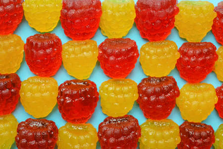 Delicious gummy raspberry candies on light blue background, flat layの写真素材