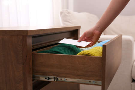 Woman putting scented sachet into drawer with clothes, closeupの写真素材