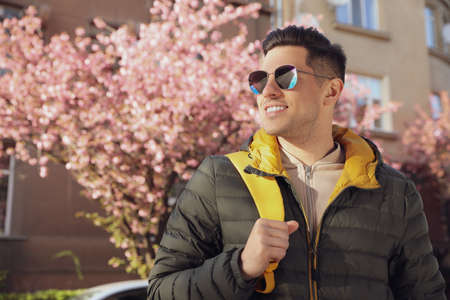 Happy male tourist sightseeing outdoors on spring dayの写真素材