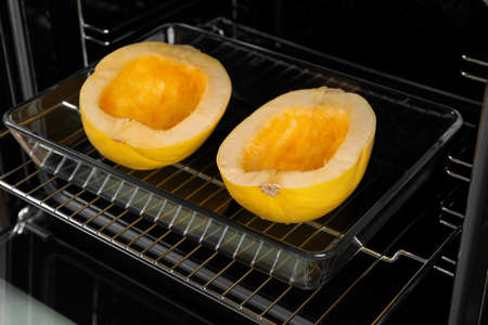 Baking dish with halves of fresh spaghetti squash in ovenの写真素材