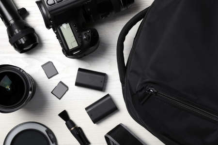 Professional photography equipment and backpack on white wooden table, flat layの写真素材