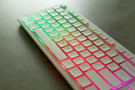Modern keyboard with RGB lighting on gray table, closeup