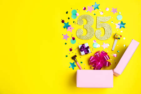 Flat lay composition with decor and numbers on yellow background, space for text. 35th birthday partyの写真素材
