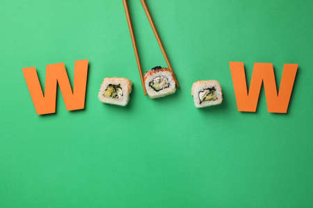 Word Wooow made with sushi rolls and paper letters on green background, flat layの写真素材