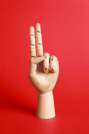 Wooden hand model on red background. Mannequin partの写真素材