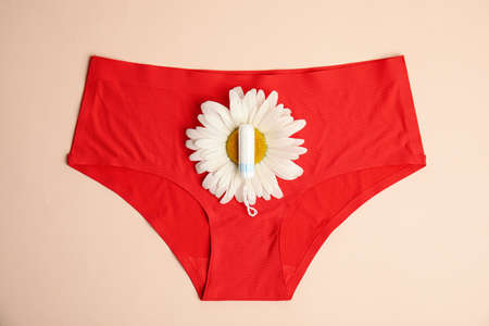 Tampon, chamomile and panties on beige background, top viewの写真素材