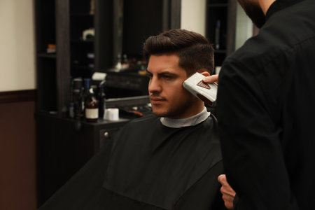 Professional hairdresser making stylish haircut in salon, closeupの写真素材