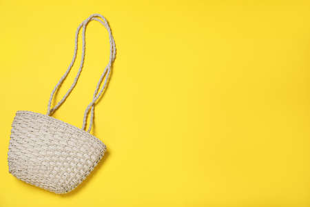 Stylish straw beach bag on yellow background, top view. Space for textの写真素材