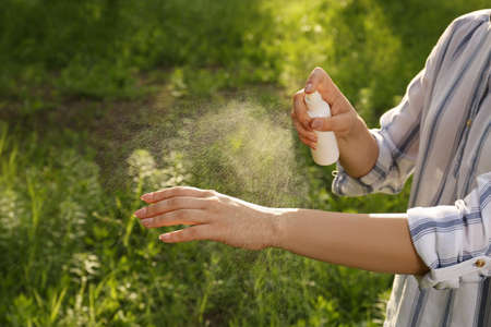Woman applying insect repellent on hand in park, closeup. Tick bites preventionの写真素材