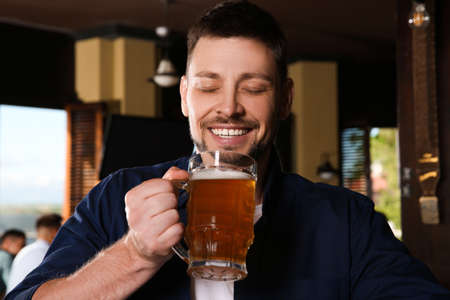 Man with glass of tasty beer in pubの写真素材