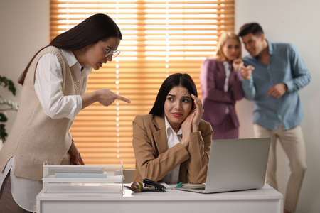 Woman scolding employee at workplace in officeの写真素材
