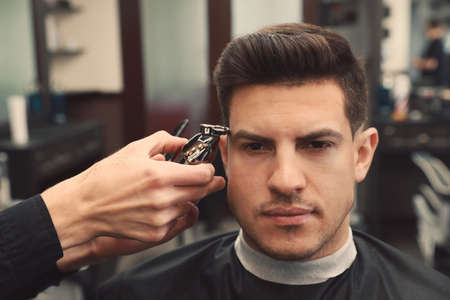 Professional hairdresser making stylish haircut in salon, closeupの写真素材