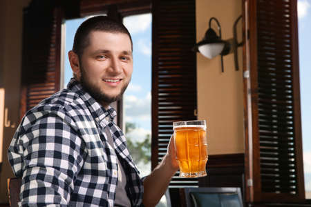 Man with glass of tasty beer in pubの写真素材