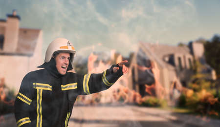 Firefighter in uniform with helmet hurrying to rescueの写真素材