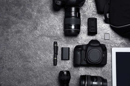 Professional photography equipment and backpack on gray stone table, flat lay. Space for textの写真素材