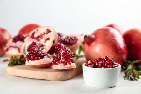Delicious ripe pomegranates on white wooden tableの写真素材