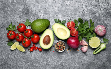 Fresh ingredients for guacamole on gray table, flat lay