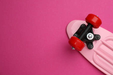 Skateboard on crimson background, top view. Space for textの写真素材