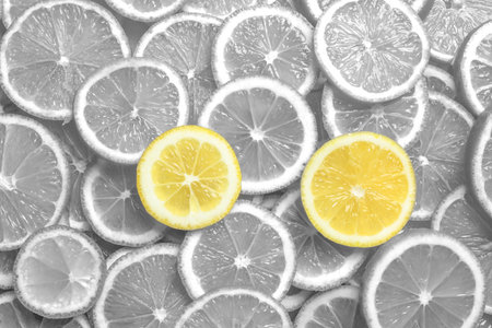 Many fresh lemon slices as background, top view. Black and white tone with selective color effectの写真素材