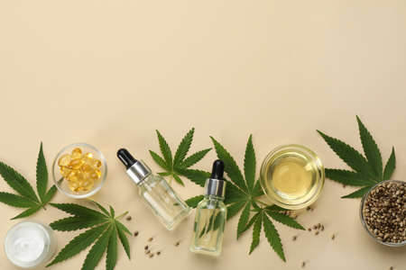 Flat lay composition with hemp leaves, CBD oil and THC tincture on beige background, space for textの写真素材