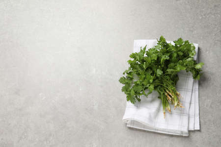 Bunch of fresh aromatic cilantro on gray table, top view. Space for textの写真素材