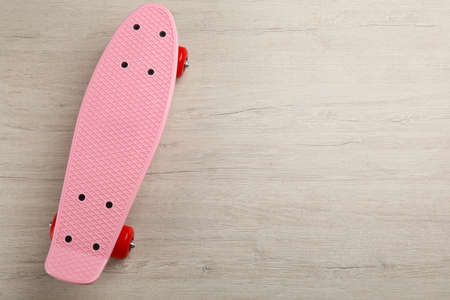 Pink skateboard on wooden background, top view. Space for textの写真素材