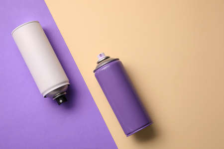 Cans of different spray paints on color background, flat lay with space for text. Graffiti suppliesの写真素材