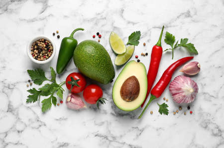 Fresh ingredients for guacamole on white marble table, flat layの写真素材