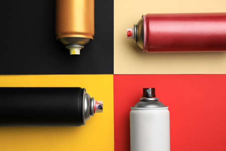 Cans of different graffiti spray paints on color background, flat layの写真素材