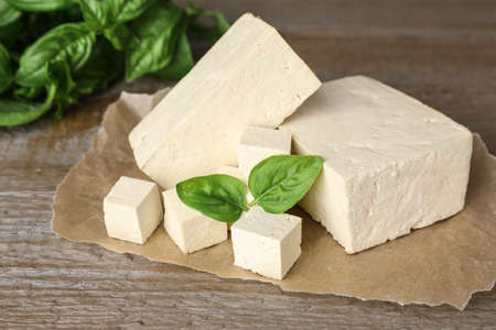 Delicious tofu with basil on wooden table