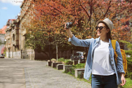 Happy female tourist with camera on city streetの写真素材