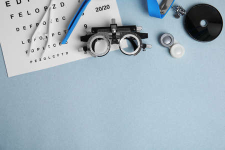 Different ophthalmologist tools on gray background, flat lay. Space for text